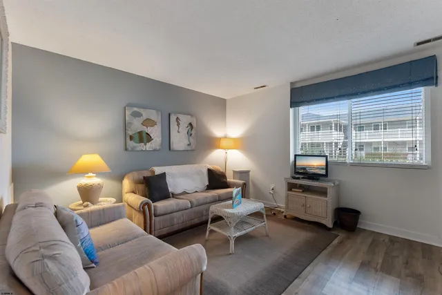 a living room with furniture and a flat screen tv with wooden floor