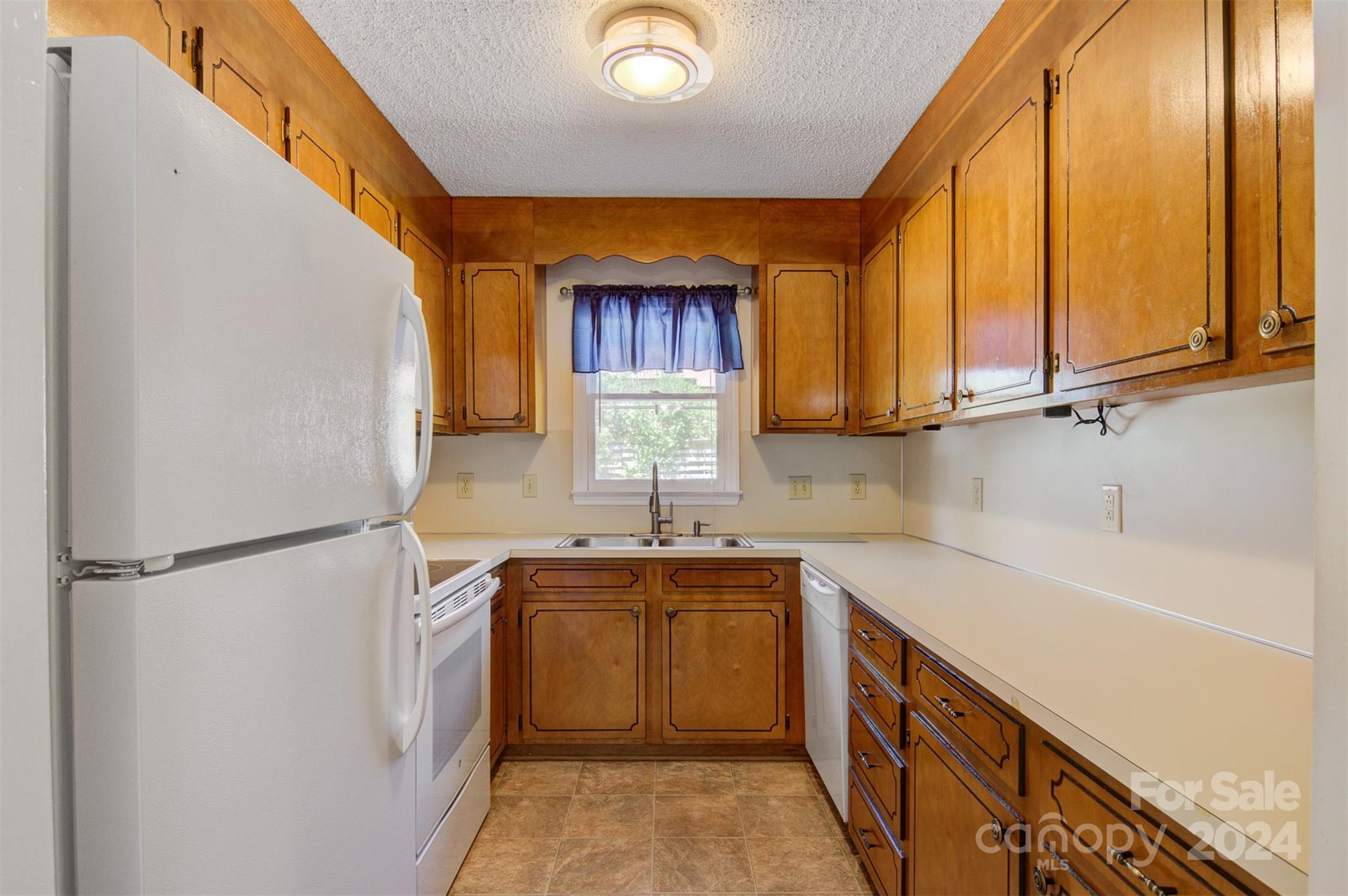 1318 5th Street Northeast Hickory, NC 28601 - Photo 13 of 27 a kitchen with a sink a refrigerator and cabinets