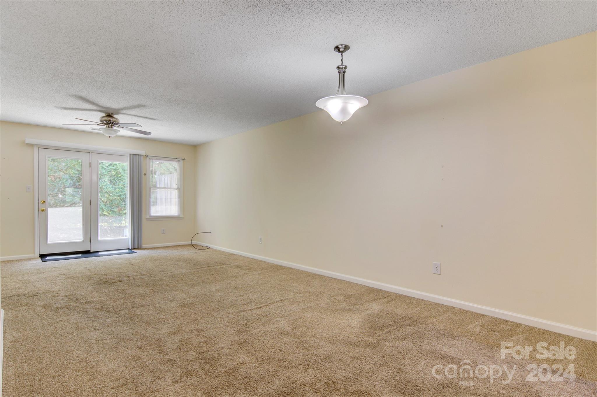 1318 5th Street Northeast Hickory, NC 28601 - Photo 4 of 27 a view of an empty room with a chandelier fan and window