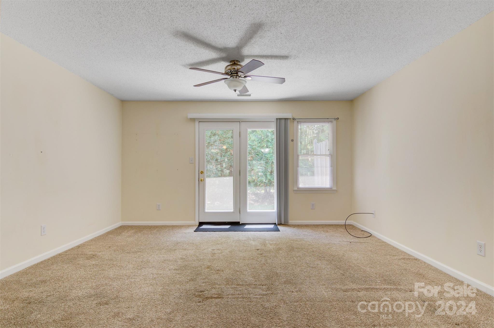1318 5th Street Northeast Hickory, NC 28601 - Photo 7 of 27 an empty room with chandelier fan and windows