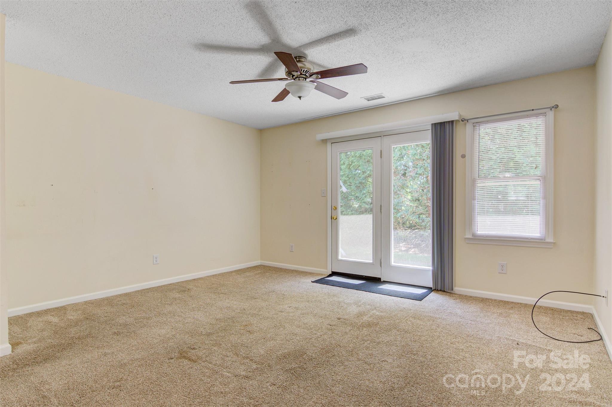 1318 5th Street Northeast Hickory, NC 28601 - Photo 8 of 27 an empty room with windows and ceiling fan