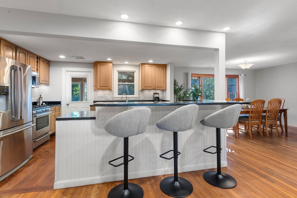 45 Bent Road Sudbury, MA 01776 - Photo 8 of 42 a kitchen with stainless steel appliances granite countertop a table chairs refrigerator and sink