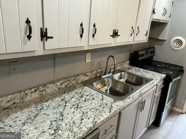 a kitchen with stainless steel appliances granite countertop a sink and a stove