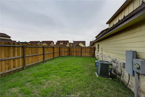 a backyard of a house with lots of green space and chair