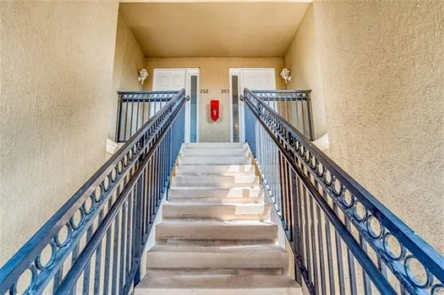 a view of staircase with lots of frames on wall and wooden floor