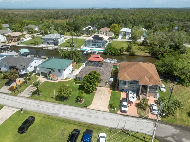 an aerial view of residential houses with outdoor space and parking