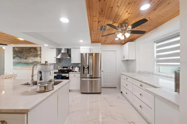 a kitchen with stainless steel appliances granite countertop a sink a stove and a refrigerator