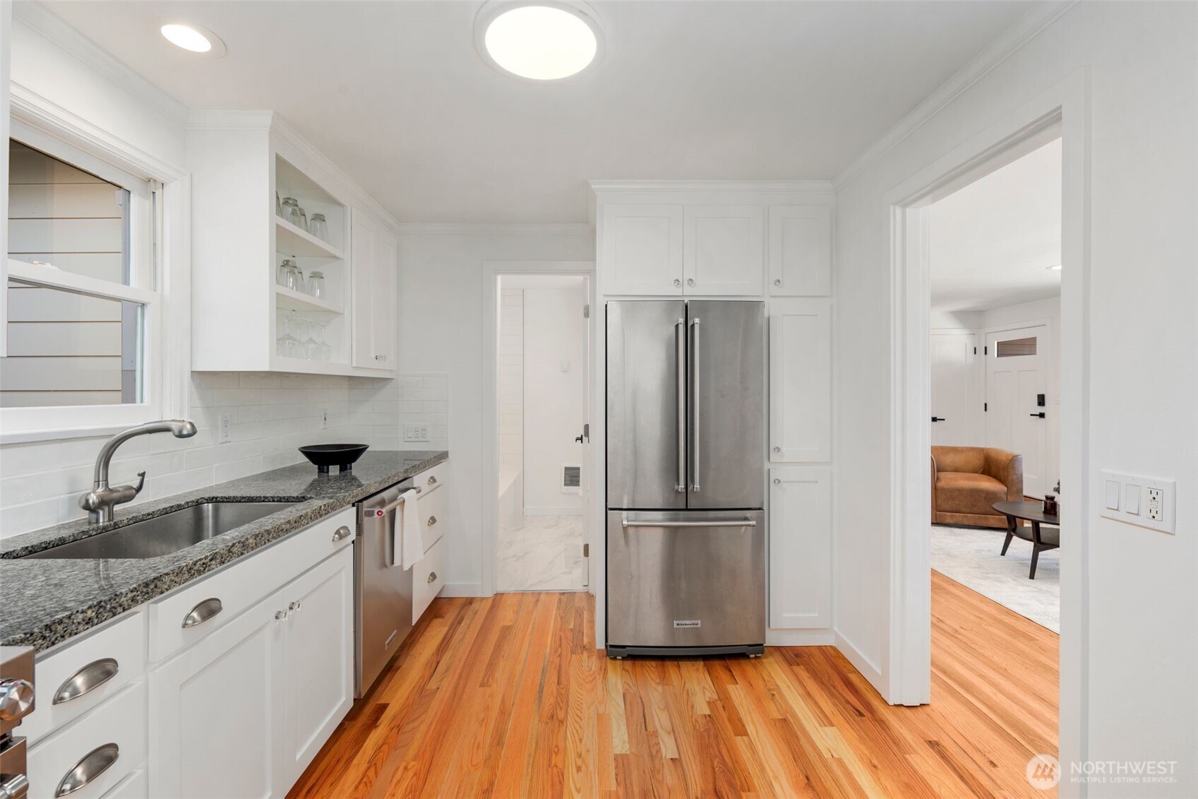 3811 Northeast 89th Street Seattle, WA 98115 - Photo 18 of 32 a kitchen with granite countertop wooden floors appliances and sink