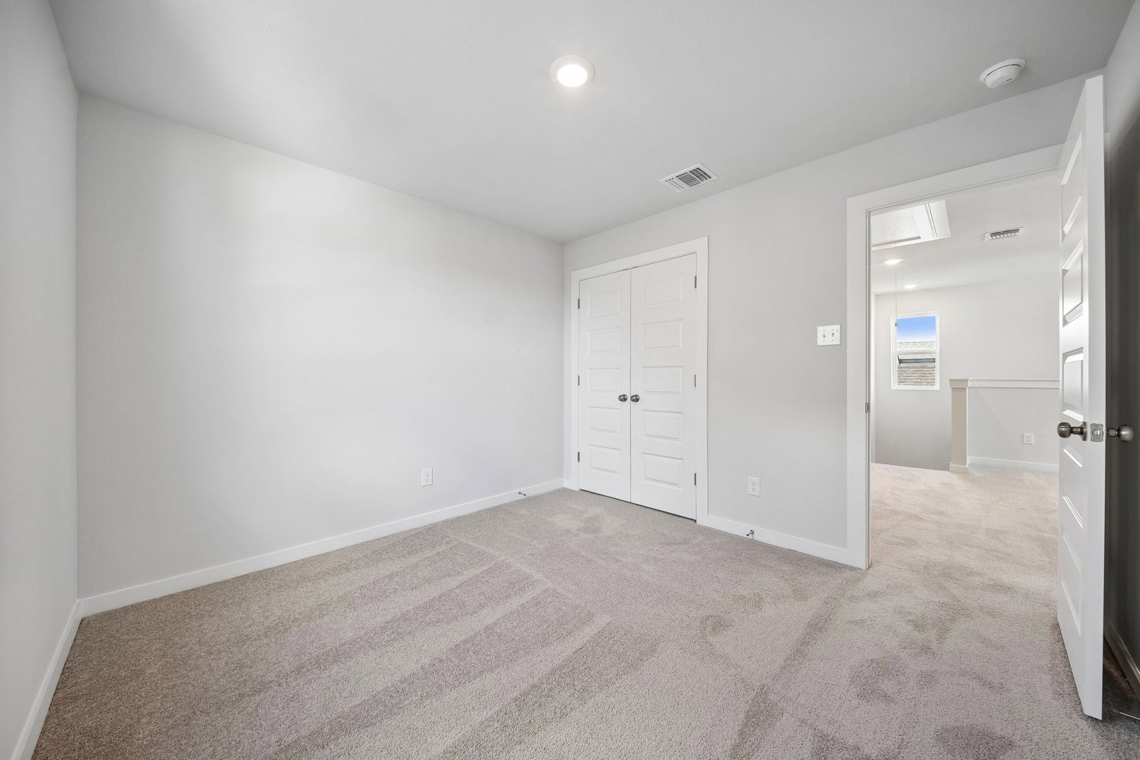 145 Hornet Street Elgin, TX 78621 - Photo 6 of 18 A spacious, naturally illuminated room features plush carpeting and a large bi-fold closet, offering comfort and convenience.