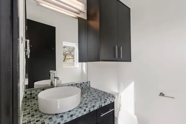 a bathroom with a granite countertop sink and mirror