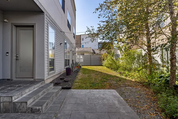 a view of a house with brick walls and a yard with couches