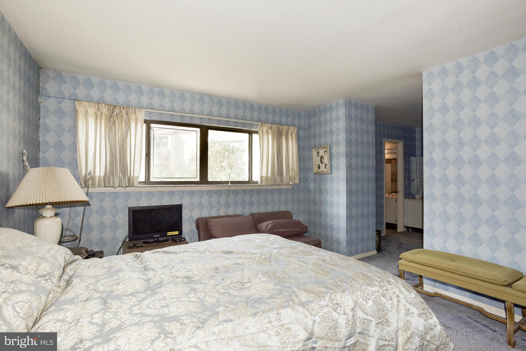 4452 Roland Springs Drive Baltimore, MD 21210 - Photo 18 of 29 a bedroom with a large bed and a chandelier
