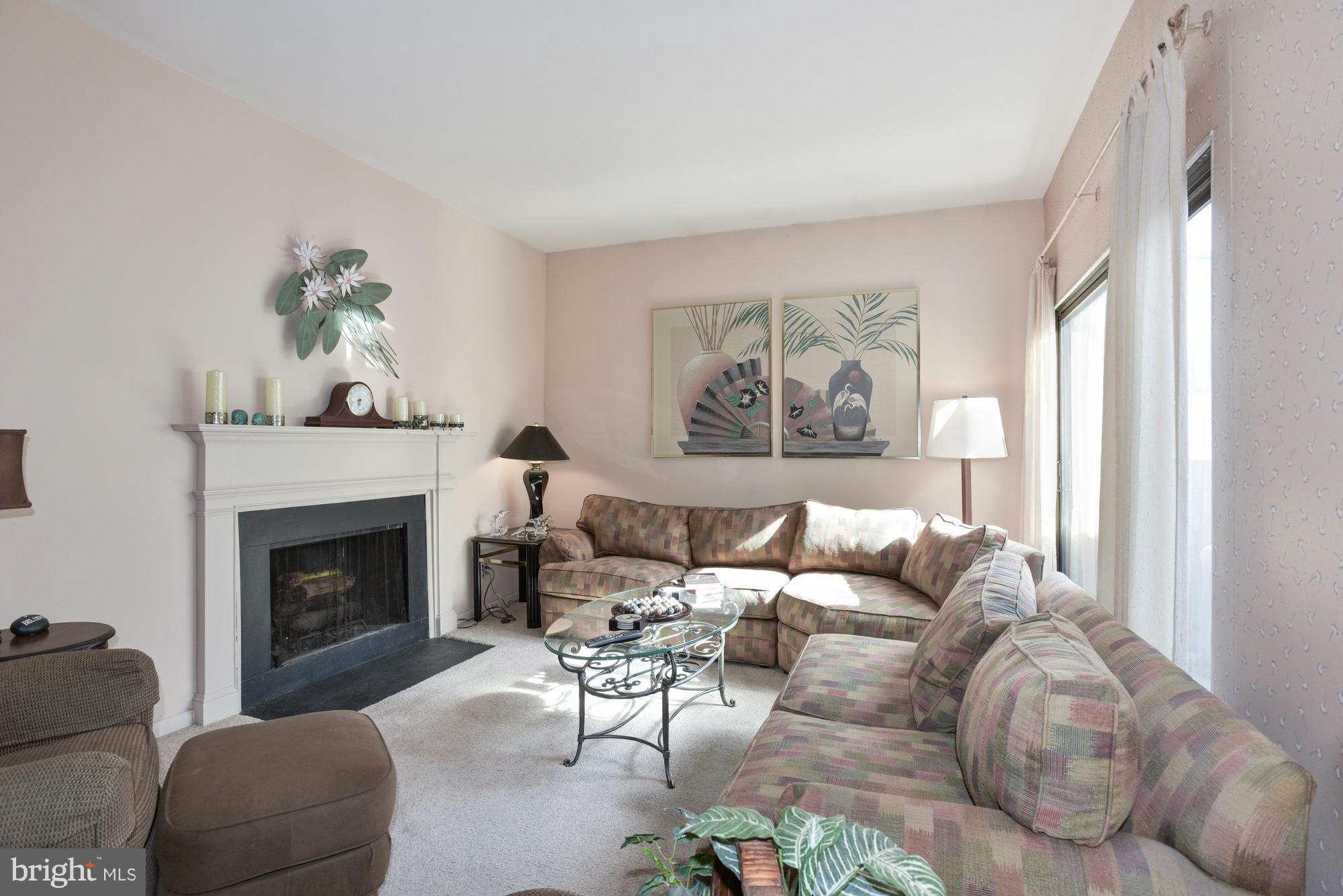 4452 Roland Springs Drive Baltimore, MD 21210 - Photo 6 of 29 a living room with furniture a fireplace and a large window