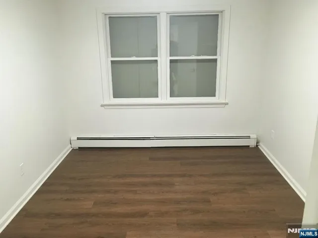 a view of a small space with wooden floor and a window