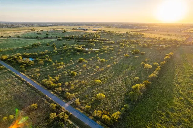an aerial view of residential houses with outdoor space and ocean view