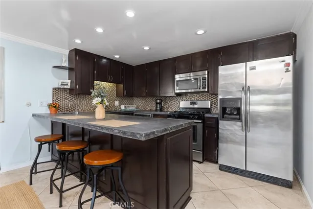a kitchen with stainless steel appliances granite countertop a stove refrigerator and a sink