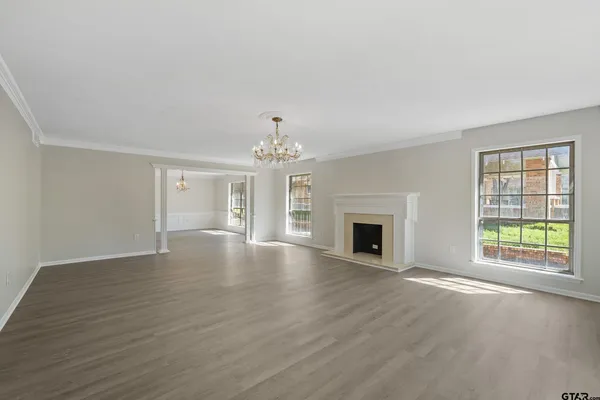 a view of an empty room with window and fire place