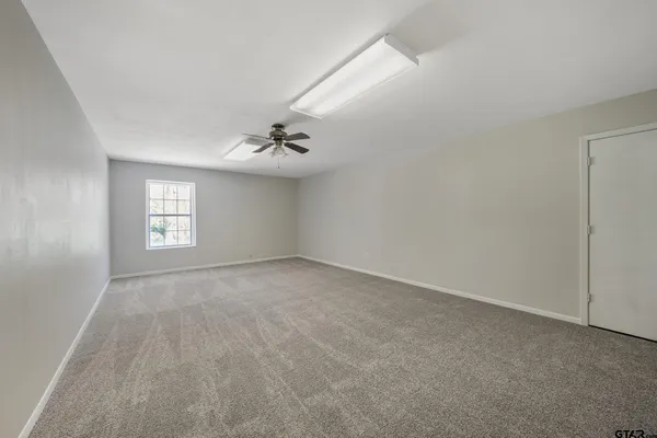 a view of an empty room with window and fire place