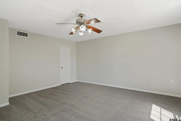 an empty room with wooden floor fireplace and windows