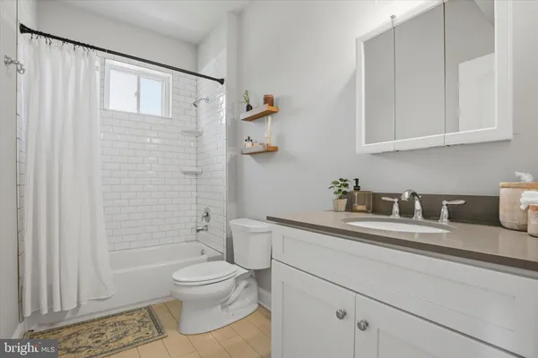 a bathroom with a granite countertop sink a toilet and shower