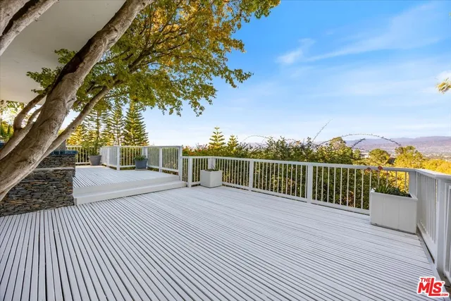 a view of an empty room with wooden floor fireplace and a window