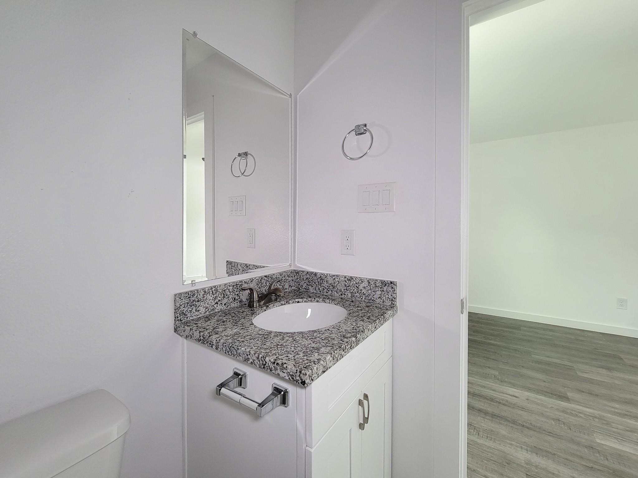 8122 Sterlingshire Street, Unit B Houston, TX 77078 - Photo 24 of 27 a bathroom with a granite countertop sink and a mirror