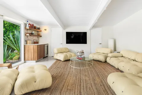 a kitchen with stainless steel appliances a table and chairs in it