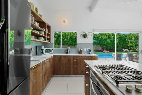 a kitchen with stainless steel appliances granite countertop a refrigerator a sink and a stove