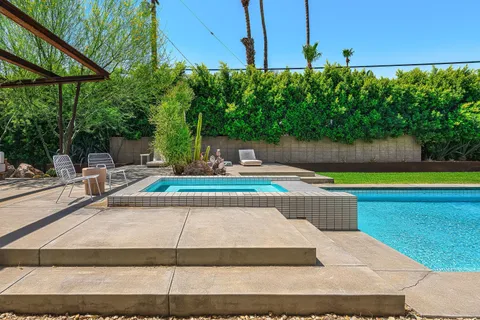 a view of a swimming pool with a yard and sitting area