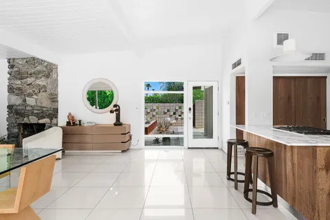 a view of a patio with a dining table and chairs next to a yard