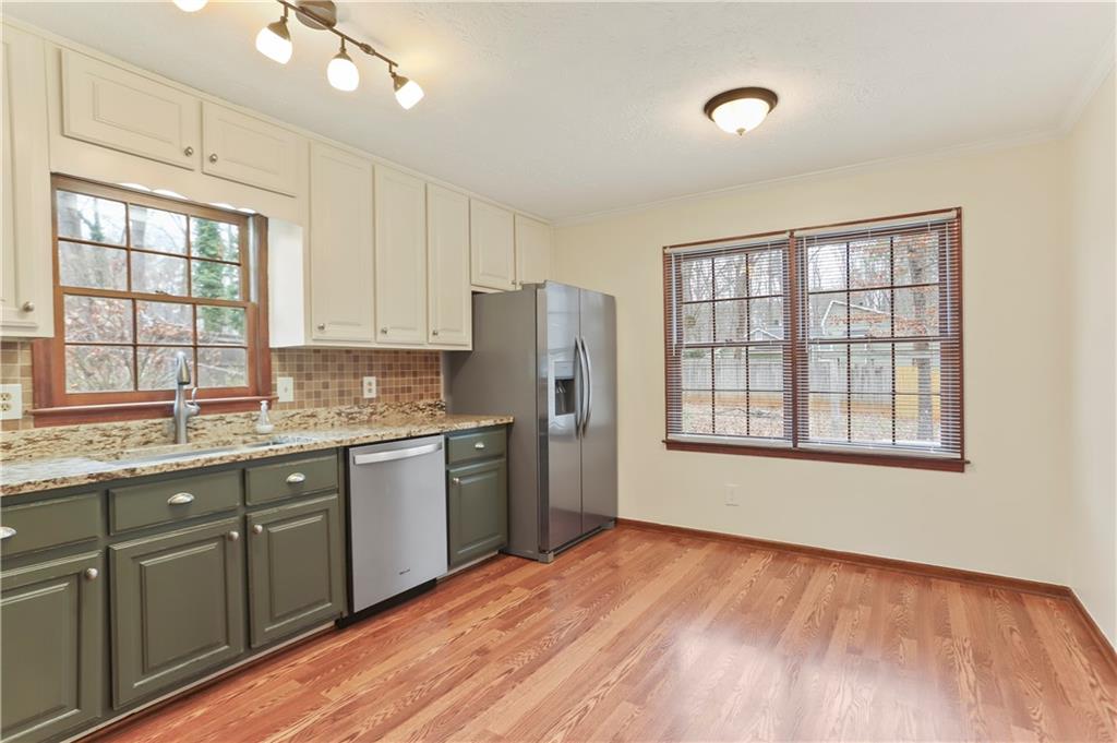 1132 Lafayette Drive Southwest Mableton, GA 30126 - Photo 11 of 35 a kitchen with stainless steel appliances granite countertop a refrigerator a sink dishwasher a stove and white countertops with wooden floor