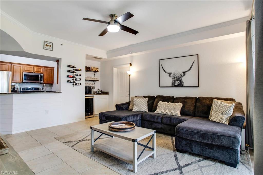 12980 Positano Circle, Unit 202 Naples, FL 34105 - Photo 1 of 27 a living room with furniture and a flat screen tv