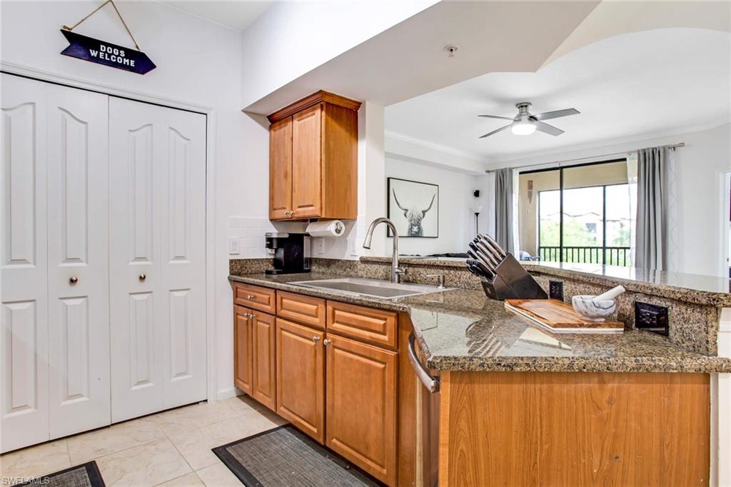 12980 Positano Circle, Unit 202 Naples, FL 34105 - Photo 12 of 27 a kitchen with granite countertop a sink stainless steel appliances and cabinets