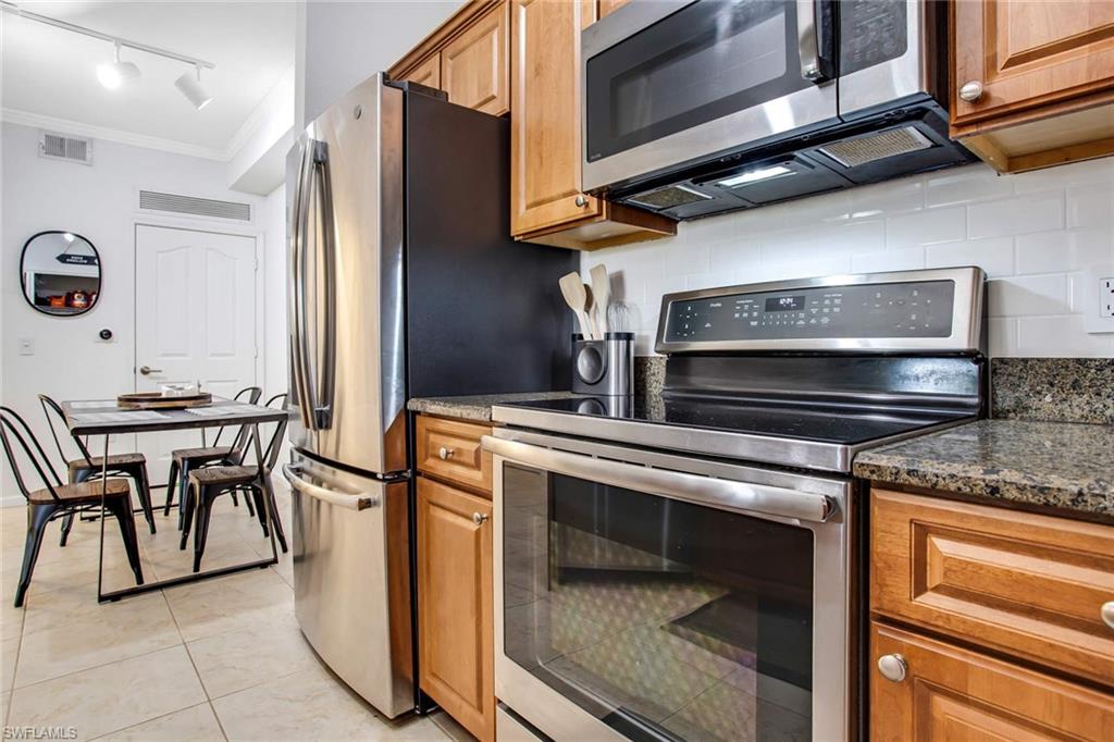 12980 Positano Circle, Unit 202 Naples, FL 34105 - Photo 13 of 27 a kitchen with appliances cabinets and furniture