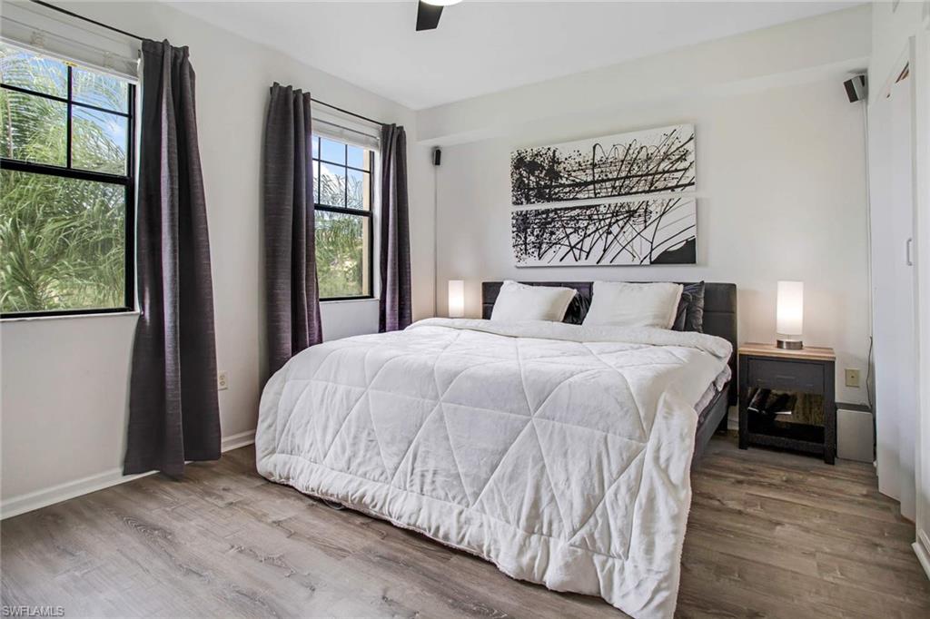 12980 Positano Circle, Unit 202 Naples, FL 34105 - Photo 15 of 27 a bedroom with a large bed and a window