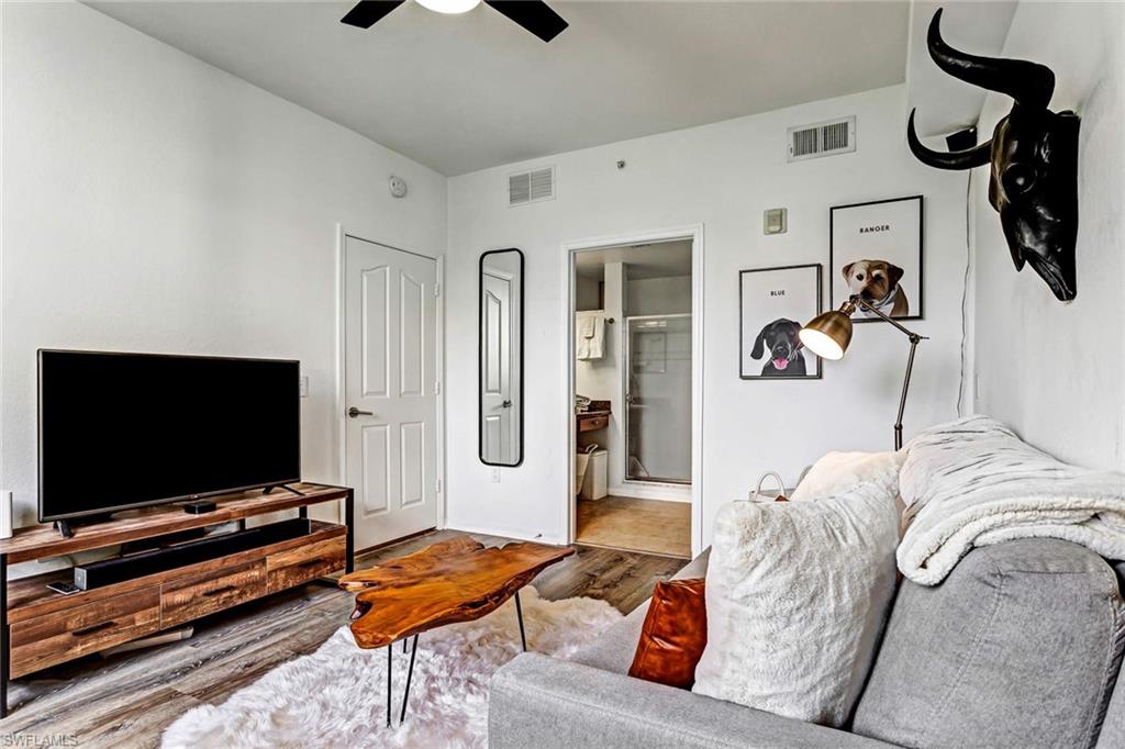 12980 Positano Circle, Unit 202 Naples, FL 34105 - Photo 21 of 27 a living room with furniture and a flat screen tv
