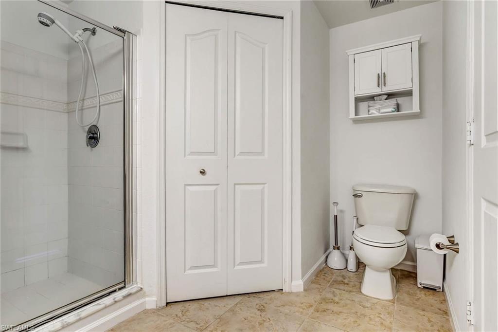 12980 Positano Circle, Unit 202 Naples, FL 34105 - Photo 23 of 27 a bathroom with a toilet and a shower