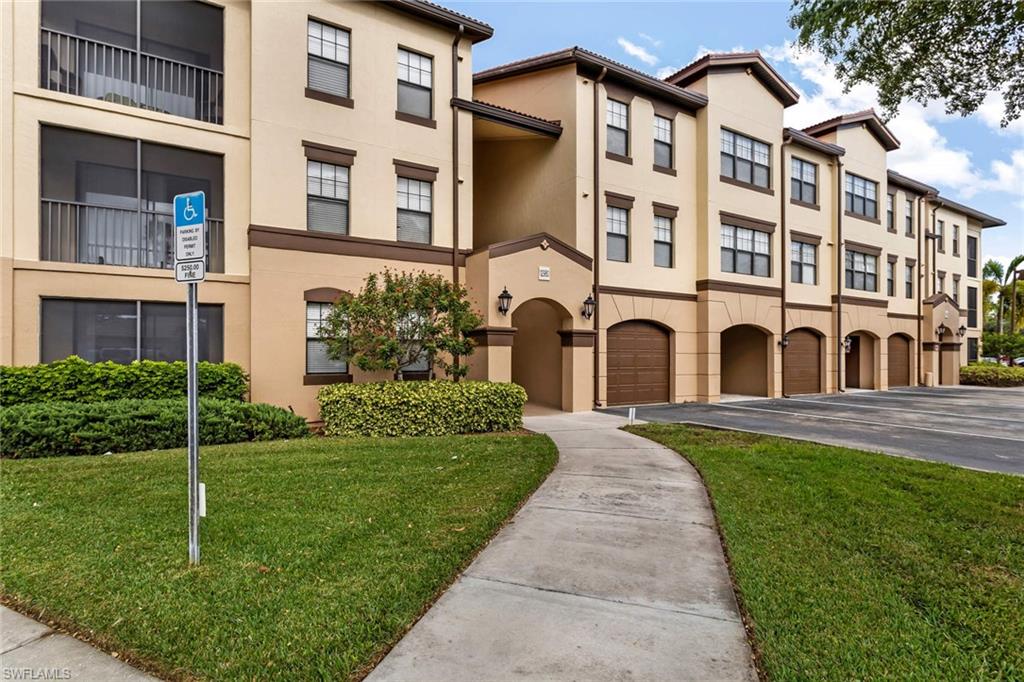 12980 Positano Circle, Unit 202 Naples, FL 34105 - Photo 26 of 27 front view of a brick house with a yard