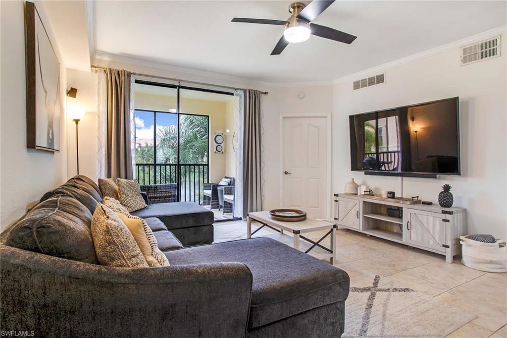 12980 Positano Circle, Unit 202 Naples, FL 34105 - Photo 3 of 27 a living room with furniture and a flat screen tv