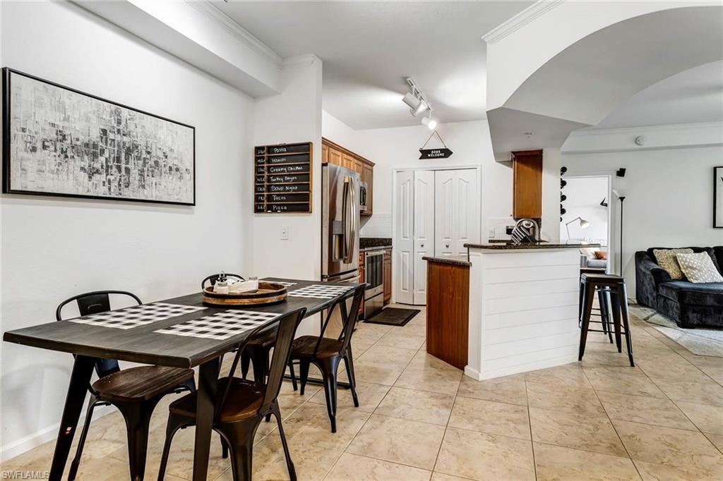 12980 Positano Circle, Unit 202 Naples, FL 34105 - Photo 7 of 27 a view of a dining room with furniture and a kitchen