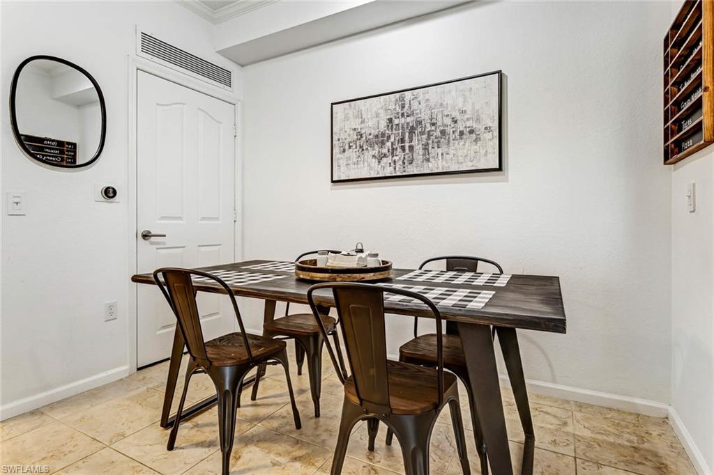 12980 Positano Circle, Unit 202 Naples, FL 34105 - Photo 8 of 27 a view of a dining room with furniture and a chandelier