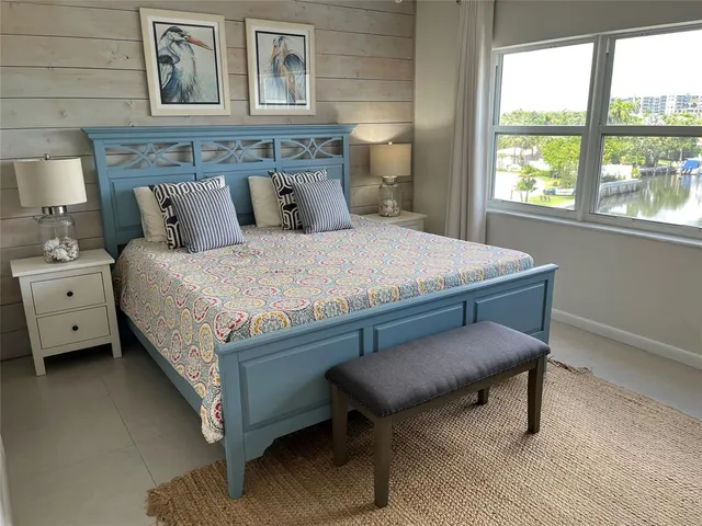 a bed sitting in a bedroom next to a window