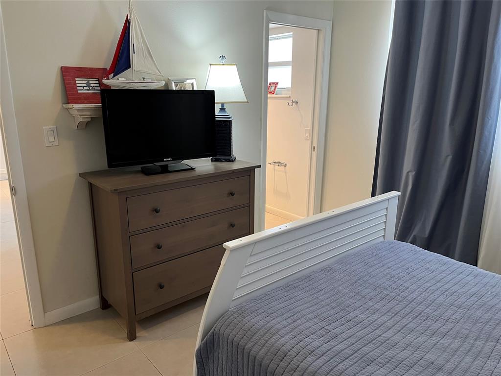 1481 South Ocean Boulevard, Unit 415A Pompano Beach, FL 33062 - Photo 23 of 39 a bedroom with a bed and flat screen tv