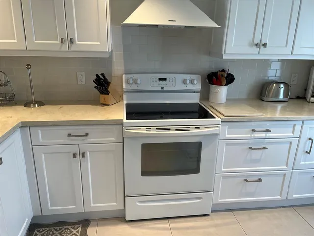 a kitchen with white cabinets and white appliances