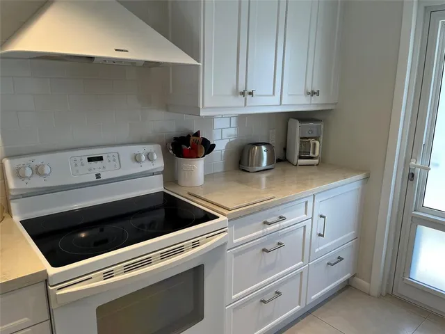 a kitchen with white cabinets and white appliances