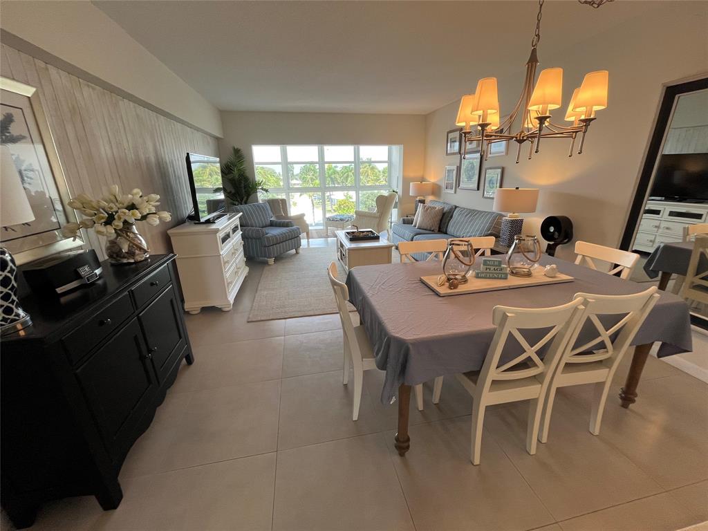 1481 South Ocean Boulevard, Unit 415A Pompano Beach, FL 33062 - Photo 33 of 39 a dining room with furniture a chandelier and wooden floor