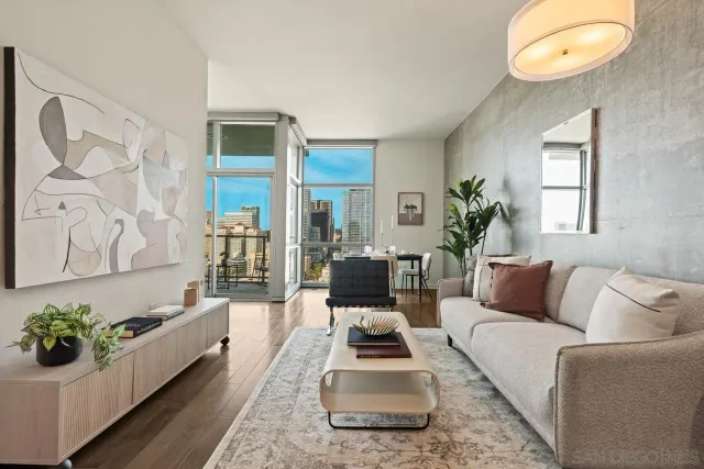 a living room with furniture wooden floor and a large window