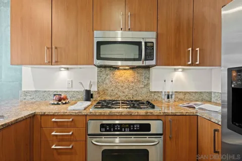 a kitchen with granite countertop a sink stove and cabinets