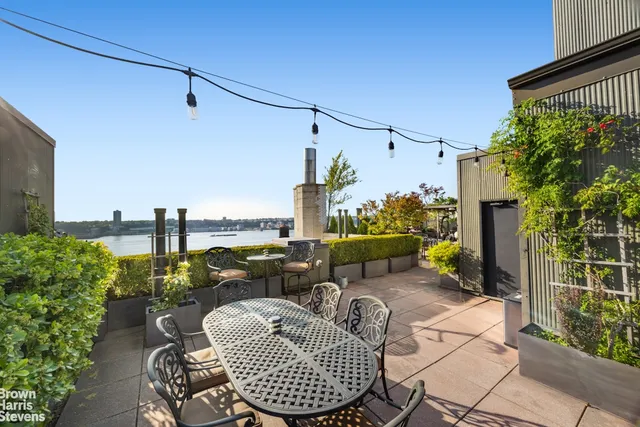 a living room with patio furniture and a potted plant