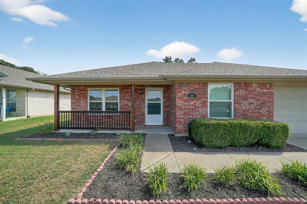 604 McAnear Street Cleburne, TX 76033 - Photo 1 of 18 a front view of a house with garden
